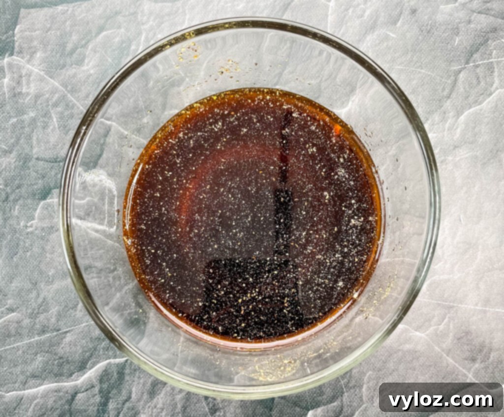 Kung Pao sauce mixture in a clear glass bowl, showcasing its rich color.