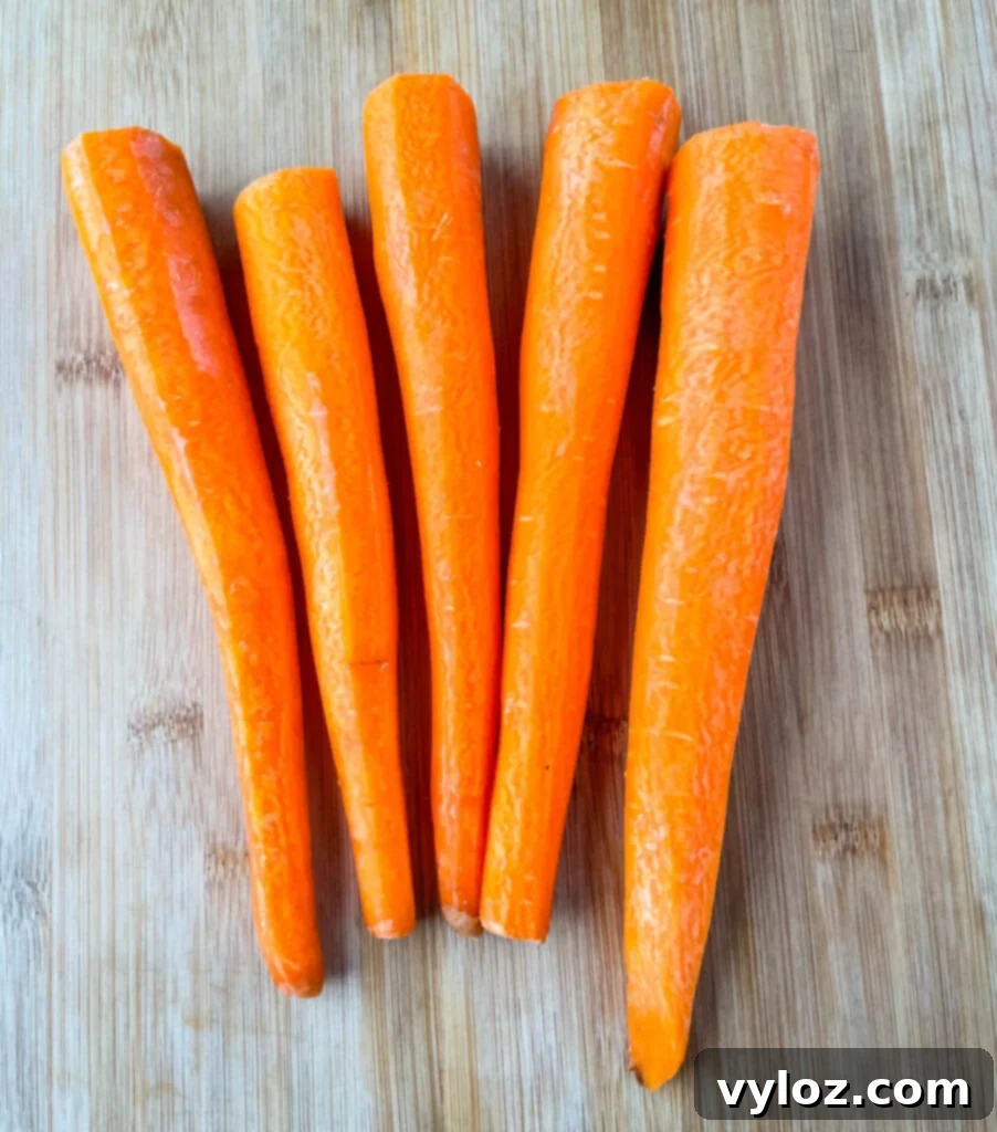 Close-up of unpeeled raw carrots on a rustic cutting board, highlighting their natural texture and earthy appeal