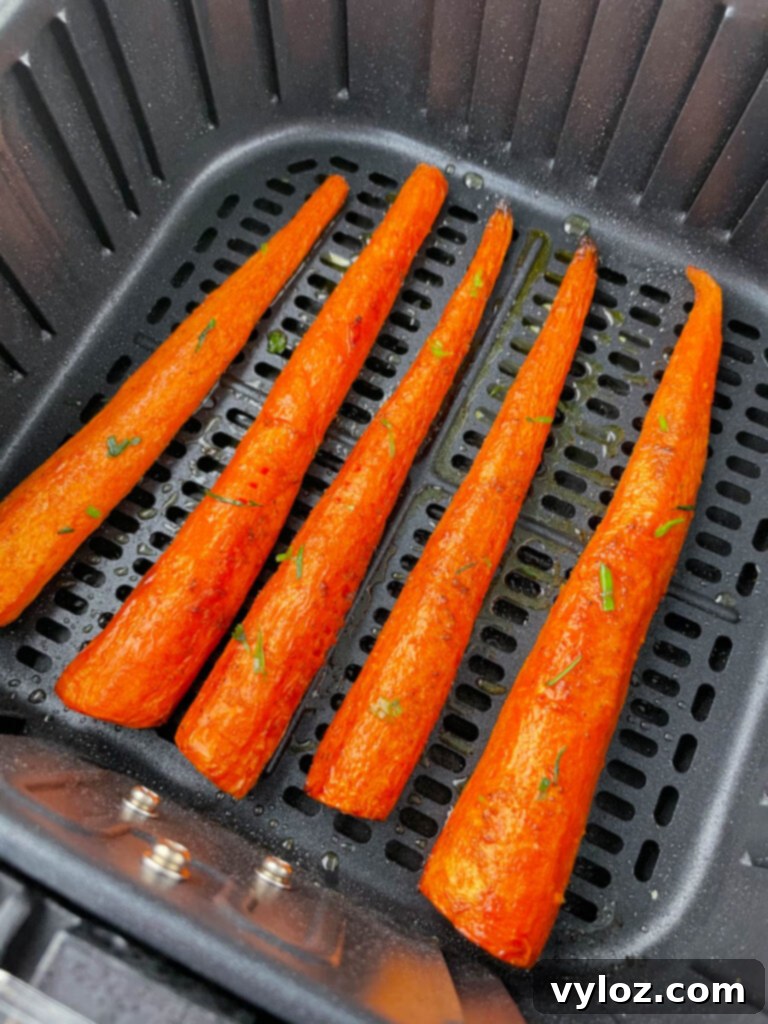 A basket full of golden-brown roasted air fryer carrots, showing their tender texture and slight caramelization, ready to be served