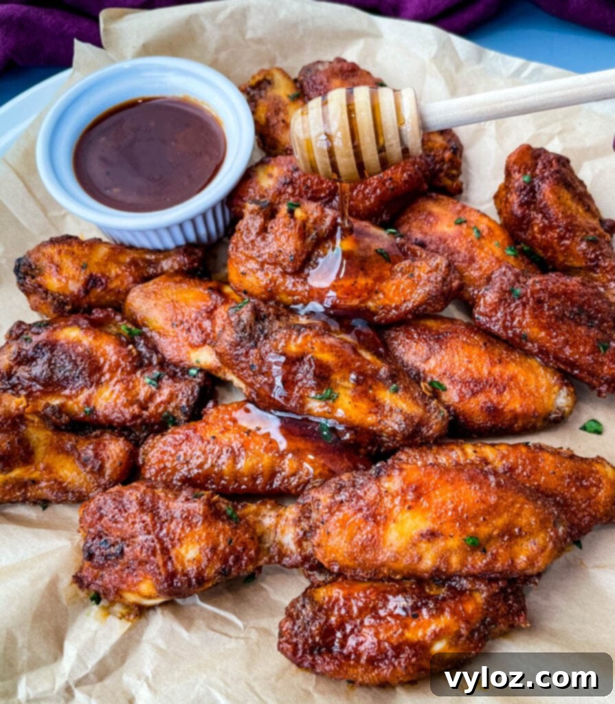 plate of keto low carb chicken wings being glazed with maple syrup