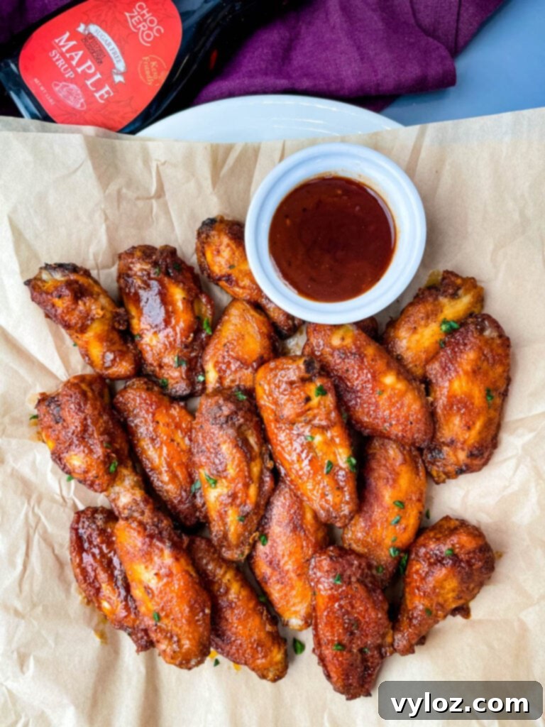 keto low carb chicken wings on a plate with maple syrup and BBQ sauce