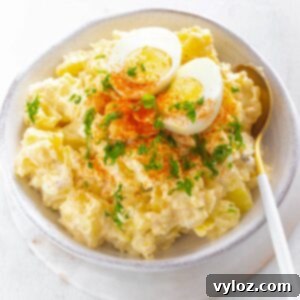 Grandmas Southern Soul Food Potato Salad 11 Instant Pot potato salad in a white bowl with boiled eggs and sprinkled with paprika