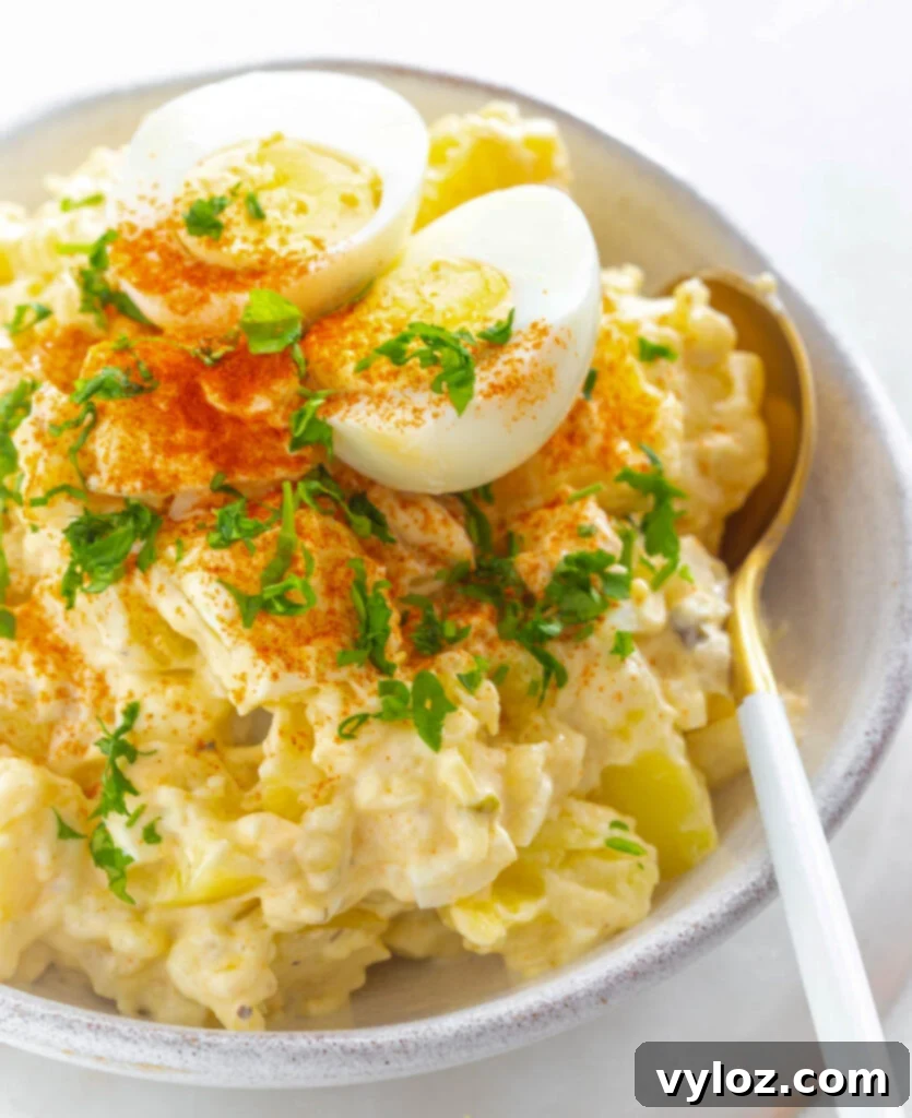 Grandmas Southern Soul Food Potato Salad 10 Instant Pot potato salad in a white bowl with boiled eggs and sprinkled with paprika