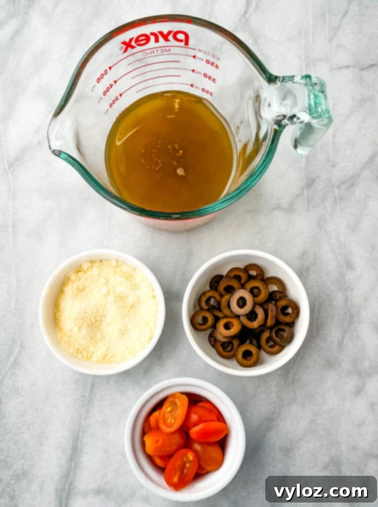 Italian dressing, Parmesan cheese, olives, and tomatoes in separate bowls