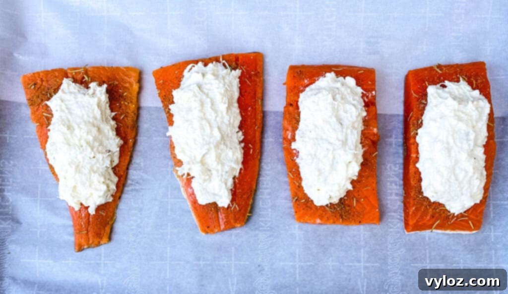 Raw crab stuffed salmon prepared on parchment paper before baking.