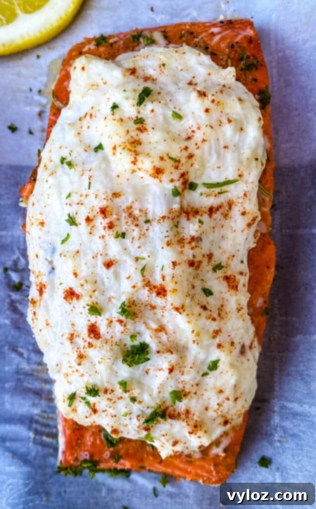 A single portion of crab stuffed salmon on parchment paper, showcasing its golden crust.