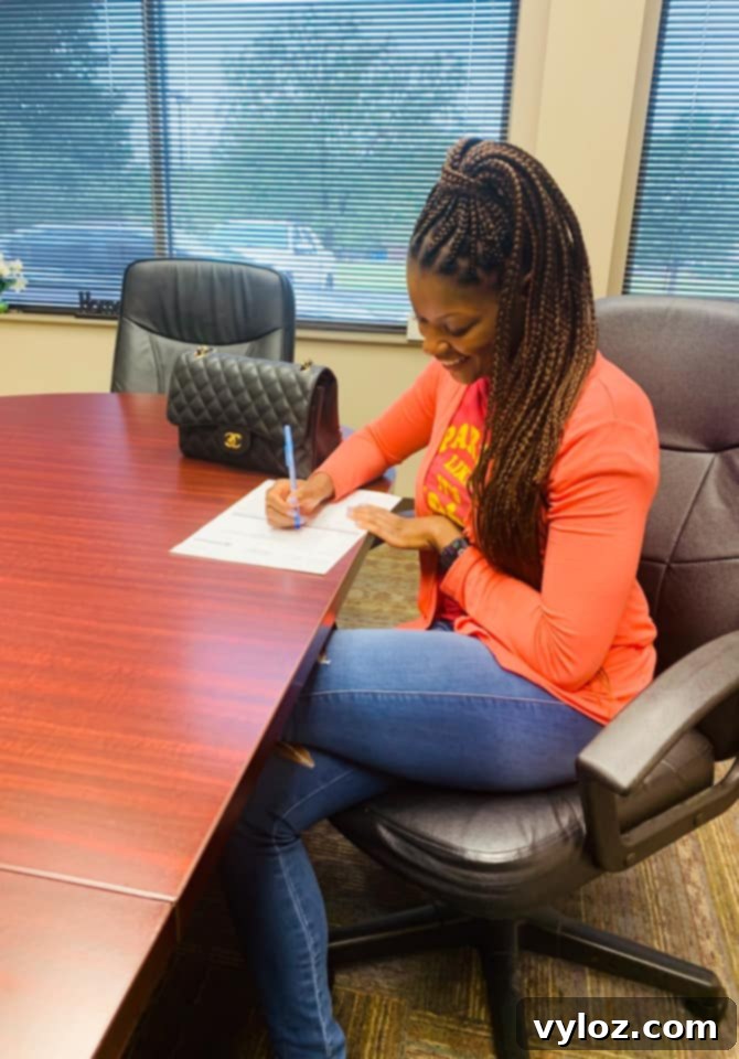 A person sits at a modern table, reviewing documents, symbolizing the administrative effort involved in a home purchase or sale.
