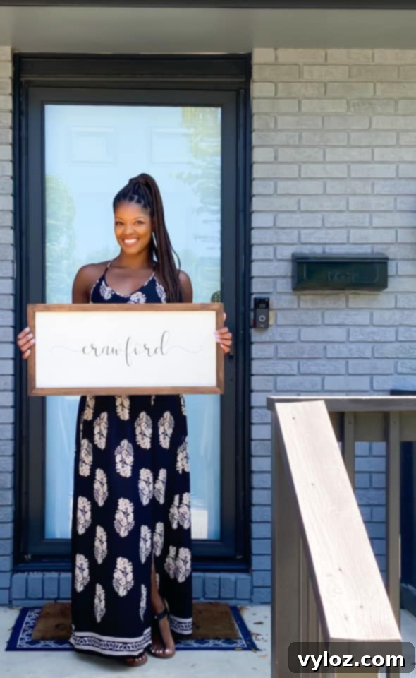 A person stands proudly in front of their new house, marked with a 'Sold' sign, symbolizing a successful move and new beginnings.