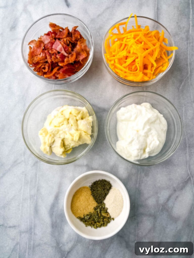 chopped bacon, shredded cheese, Greek yogurt, mayo, and homemade ranch seasoning in separate glass bowls