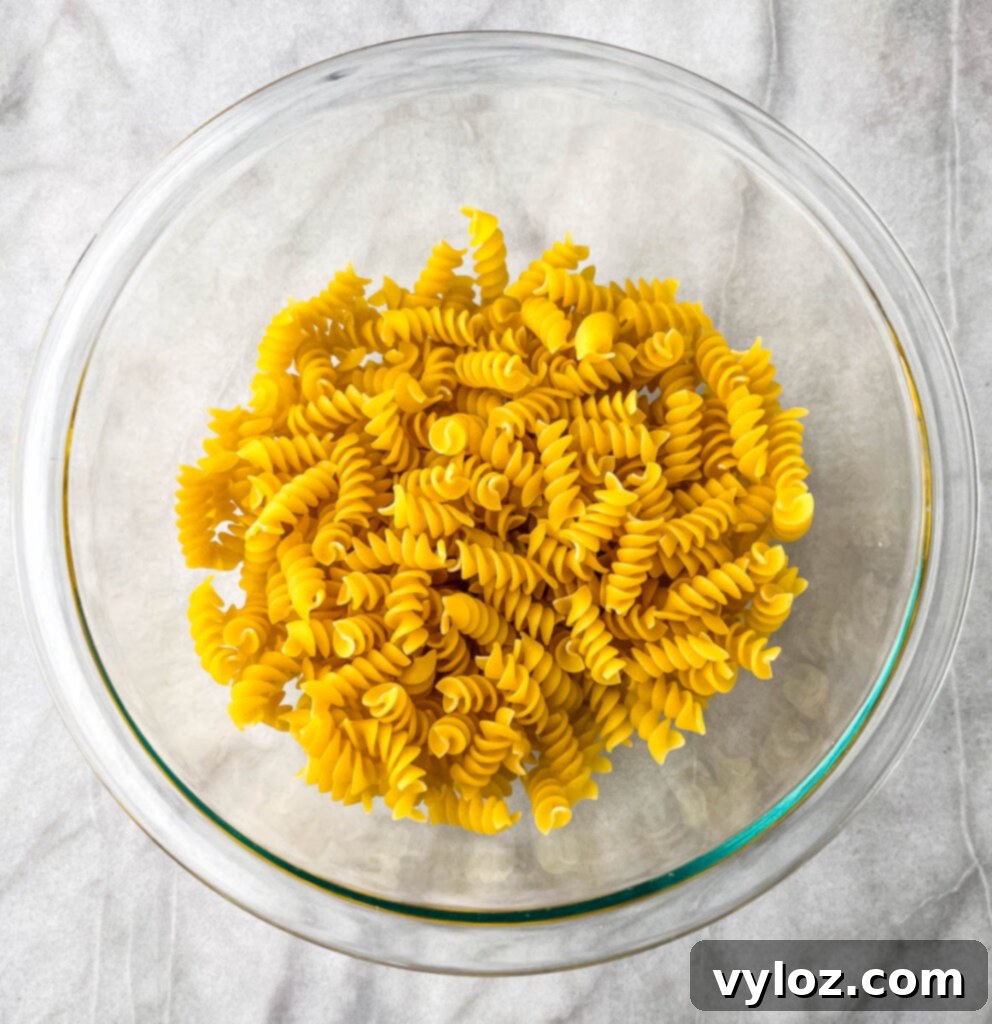 uncooked rotini pasta in a glass bowl