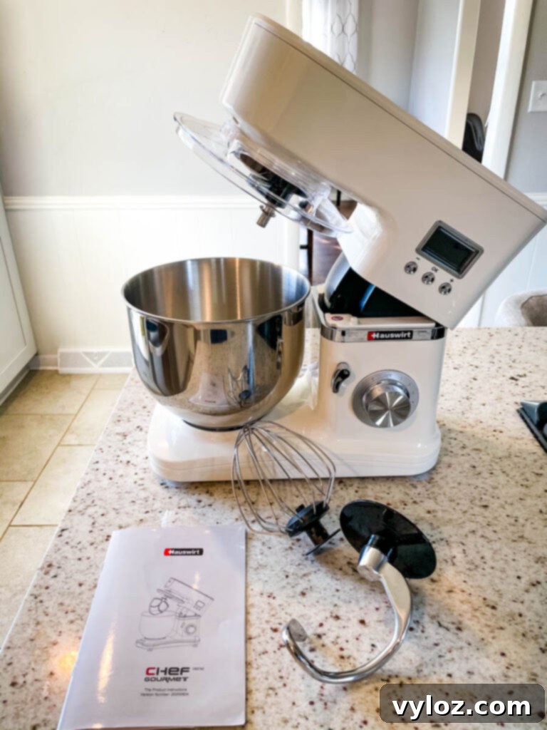 Hauswirt stand mixer with various attachments scattered on a kitchen counter