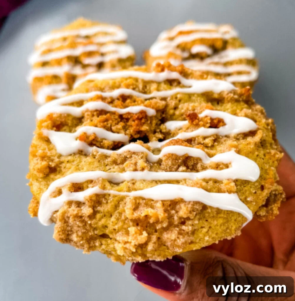 Simple Cinnamon Streusel Coffee Cake Muffins 11 person holding coffee cake muffins with icing