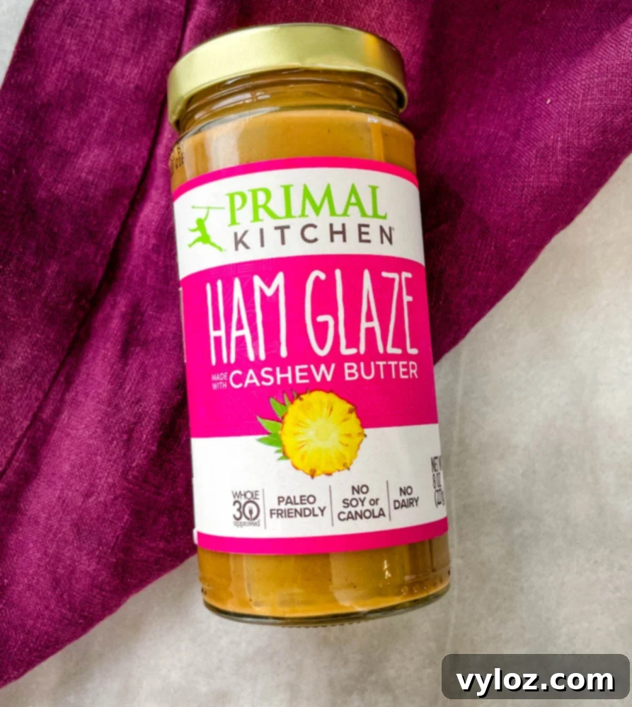 A bottle of Primal Kitchen Ham Glaze, a key ingredient for enhancing the panini's flavor, presented on a light background.
