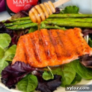 Sweet and Simple Maple Salmon 10 maple glazed salmon drizzled in syrup on a plate with asparagus and mixed greens