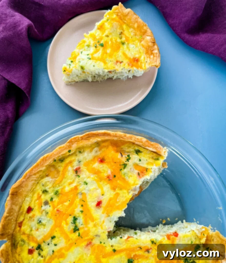 A slice of perfectly baked shrimp and crab quiche on a plate, showcasing its fluffy filling and golden crust.