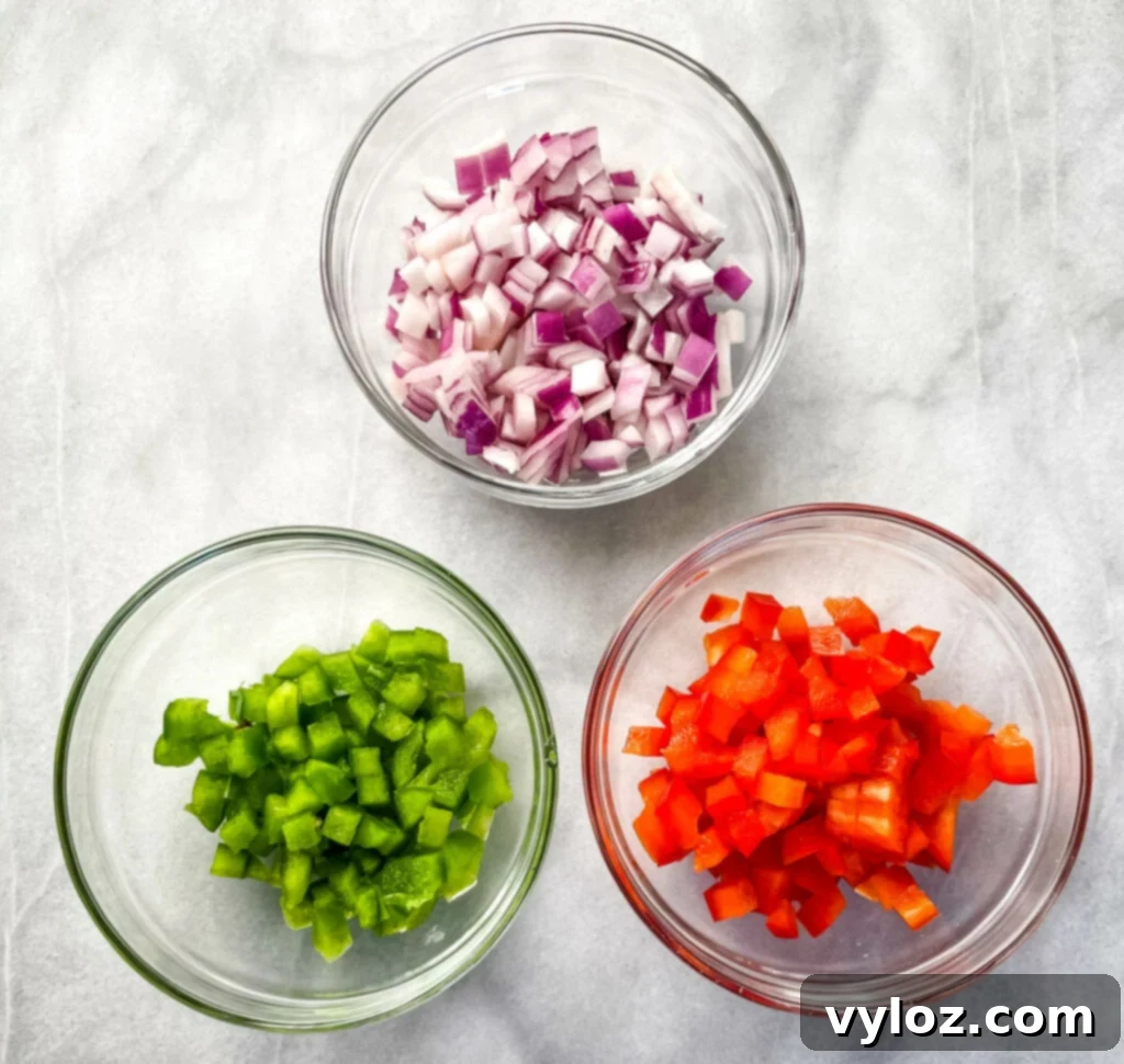 Bowls of freshly chopped onions, green peppers, and red onions, ready for the quiche preparation.