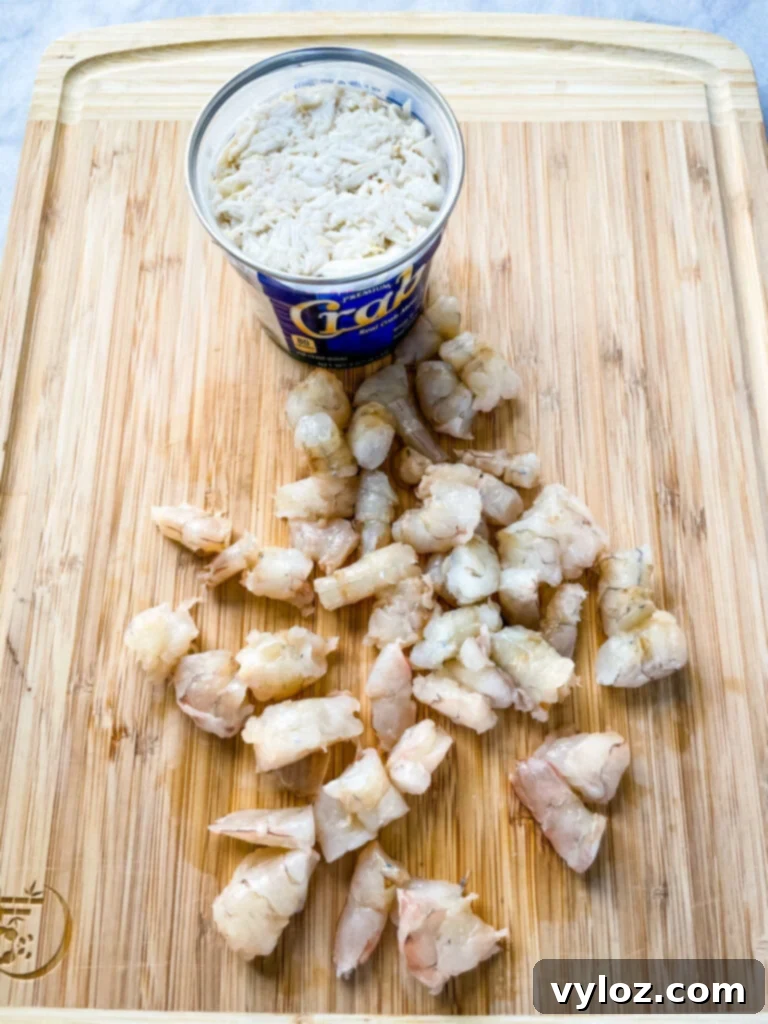 Raw shrimp and jumbo lump crab meat on a cutting board, prepared for the quiche.