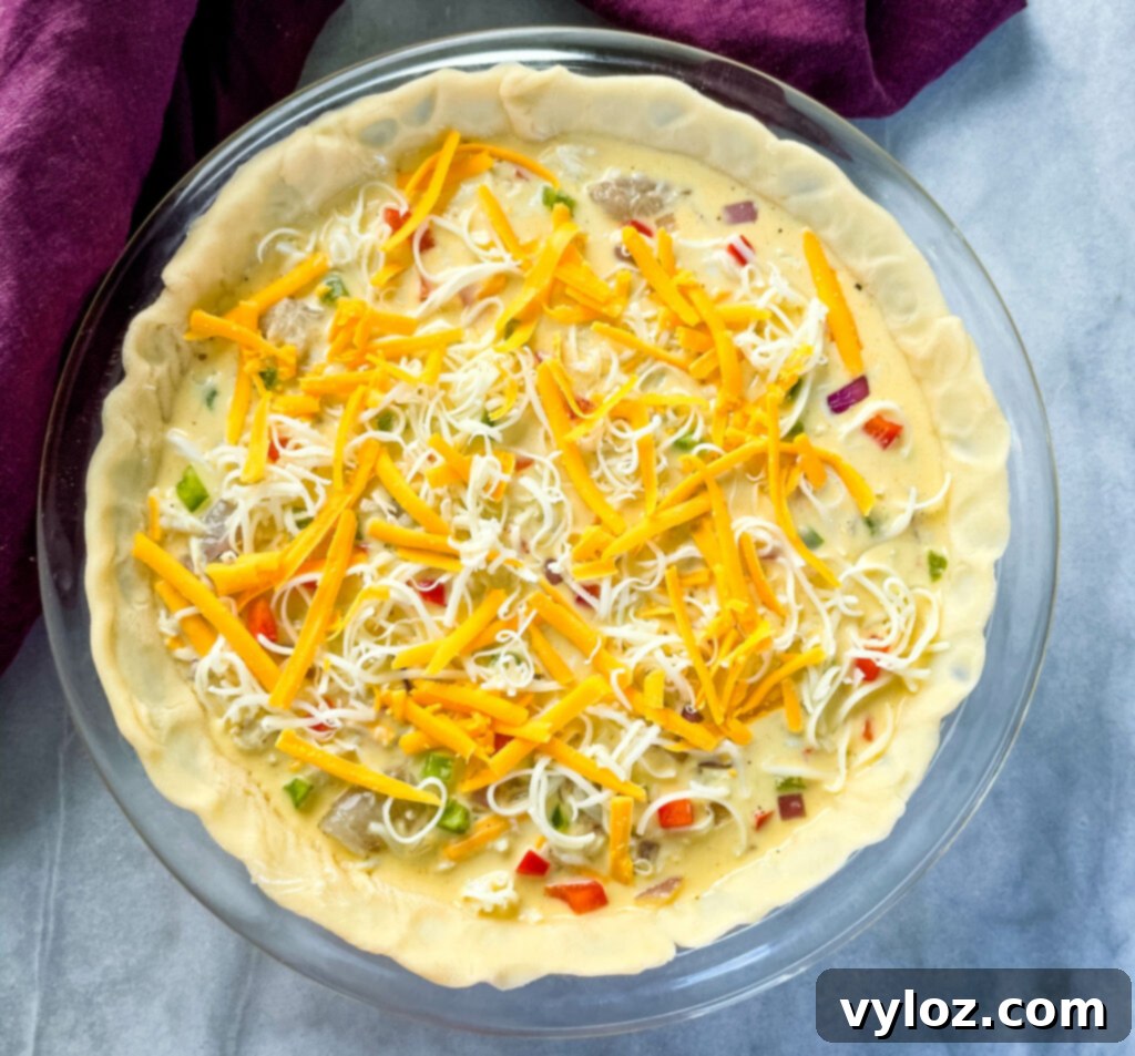 An unbaked shrimp and crab seafood quiche in a pie pan, ready for the oven.