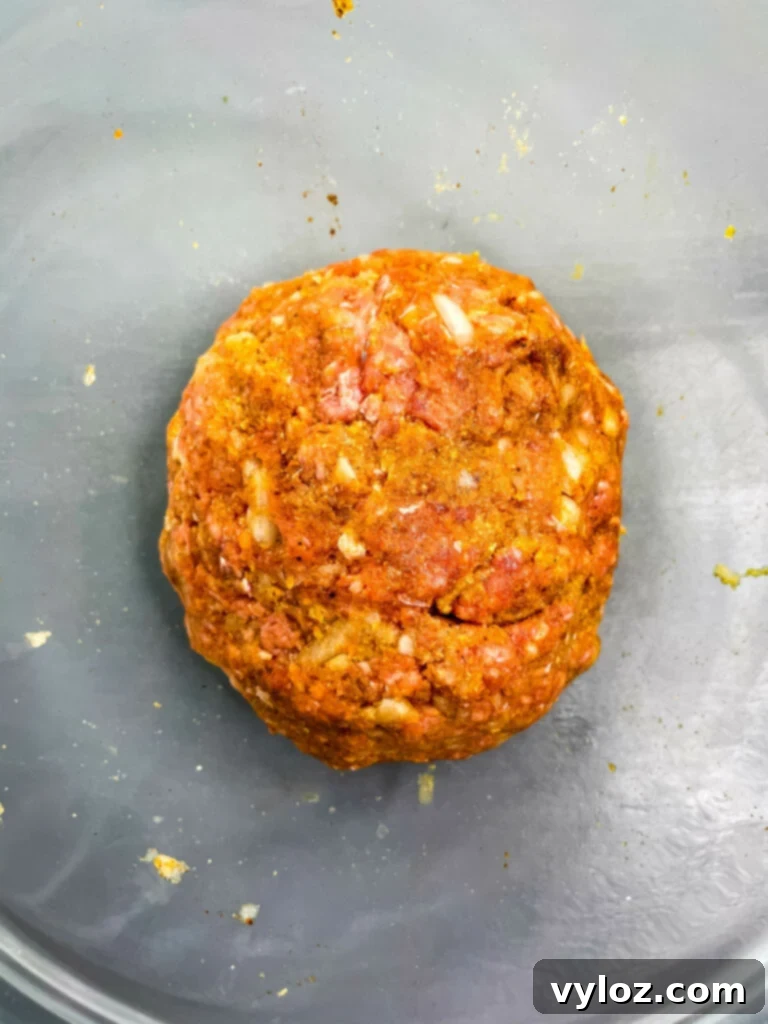 Set-It-and-Forget-It BBQ Meatballs 5 Raw meatball mixture in a glass bowl after mixing, showing a consistent texture
