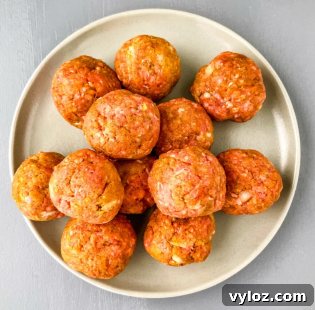 Set-It-and-Forget-It BBQ Meatballs 7 Raw meatballs neatly arranged on a plate, ready for the slow cooker