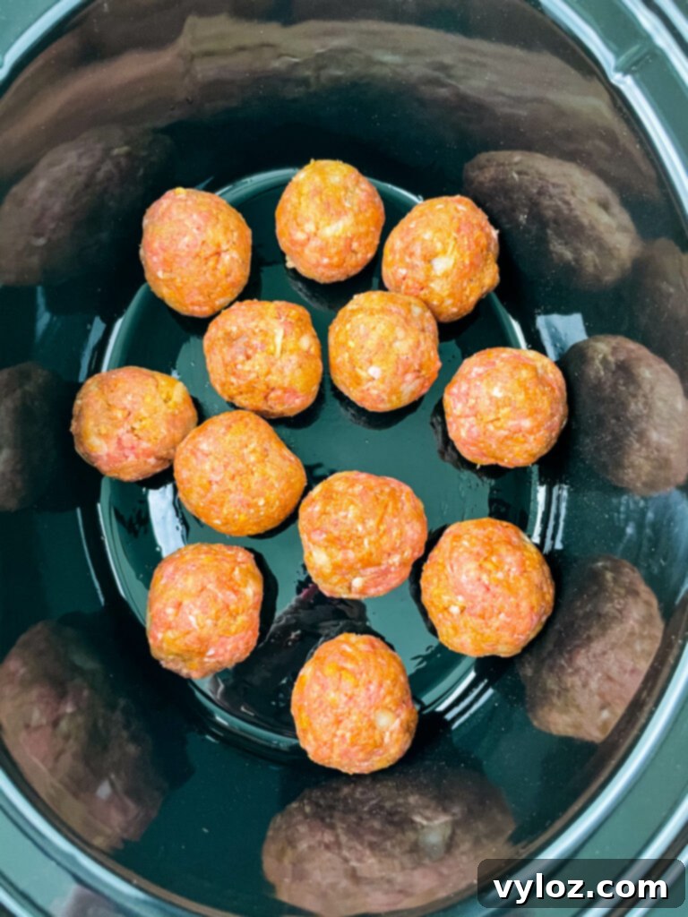 Set-It-and-Forget-It BBQ Meatballs 8 Raw meatballs arranged in a slow cooker, ready for cooking