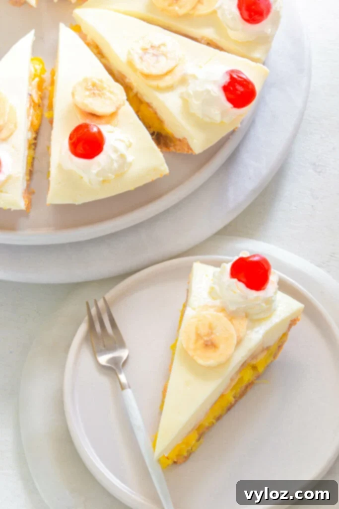A slice of No-Bake Banana Split Pie on a white plate, topped with whipped cream, a maraschino cherry, and a drizzle of chocolate syrup.