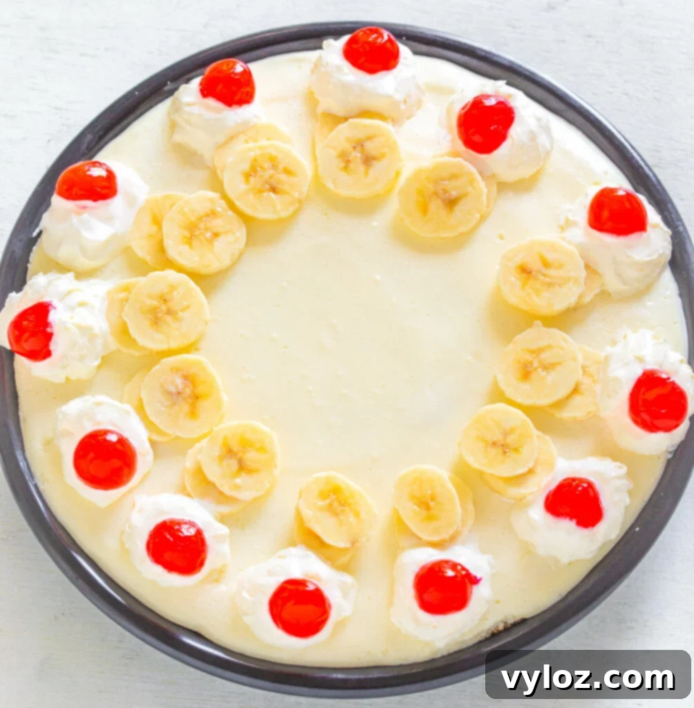 The finished No-Bake Banana Split Pie in a pie plate, freshly garnished with cherries and ready for chilling.
