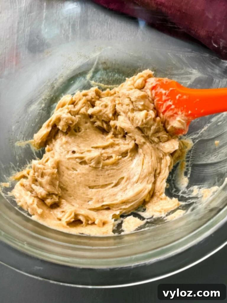 A glass bowl filled with fluffy, light brown whipped maple butter, showcasing its creamy texture and inviting appearance.