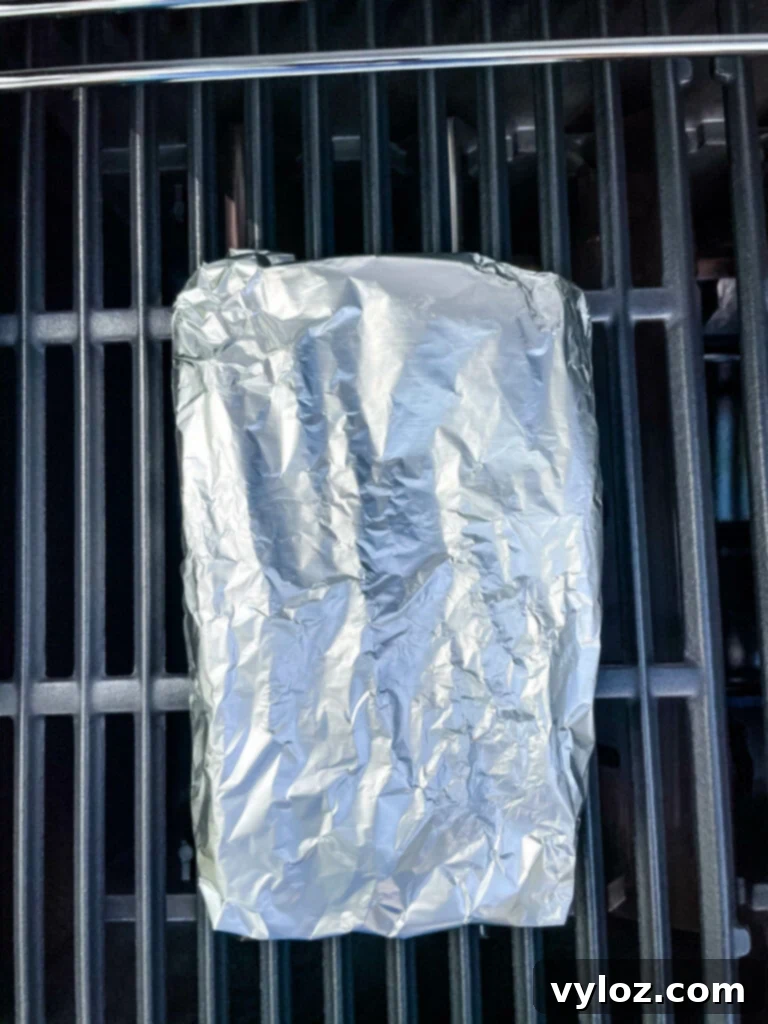 Grilled Asparagus Foil Packets 6 Foil-wrapped asparagus packet cooking on a hot grill