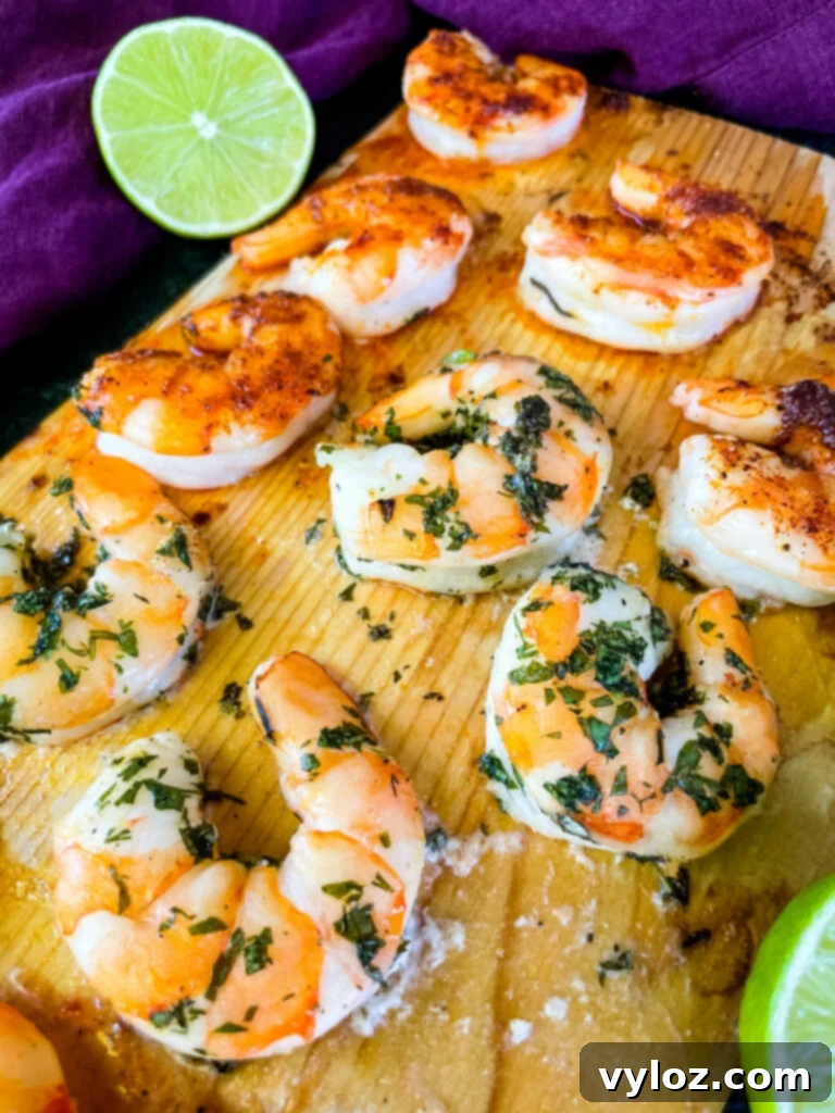 Grilled shrimp elegantly arranged on a cedar plank, ready to serve.