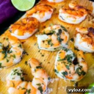 Grilled shrimp beautifully arranged on a cedar plank, showcasing its appealing presentation.
