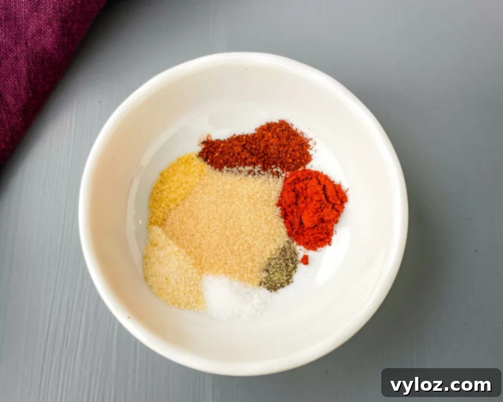 A bowl filled with homemade BBQ rub and seasoning, rich in color and texture.