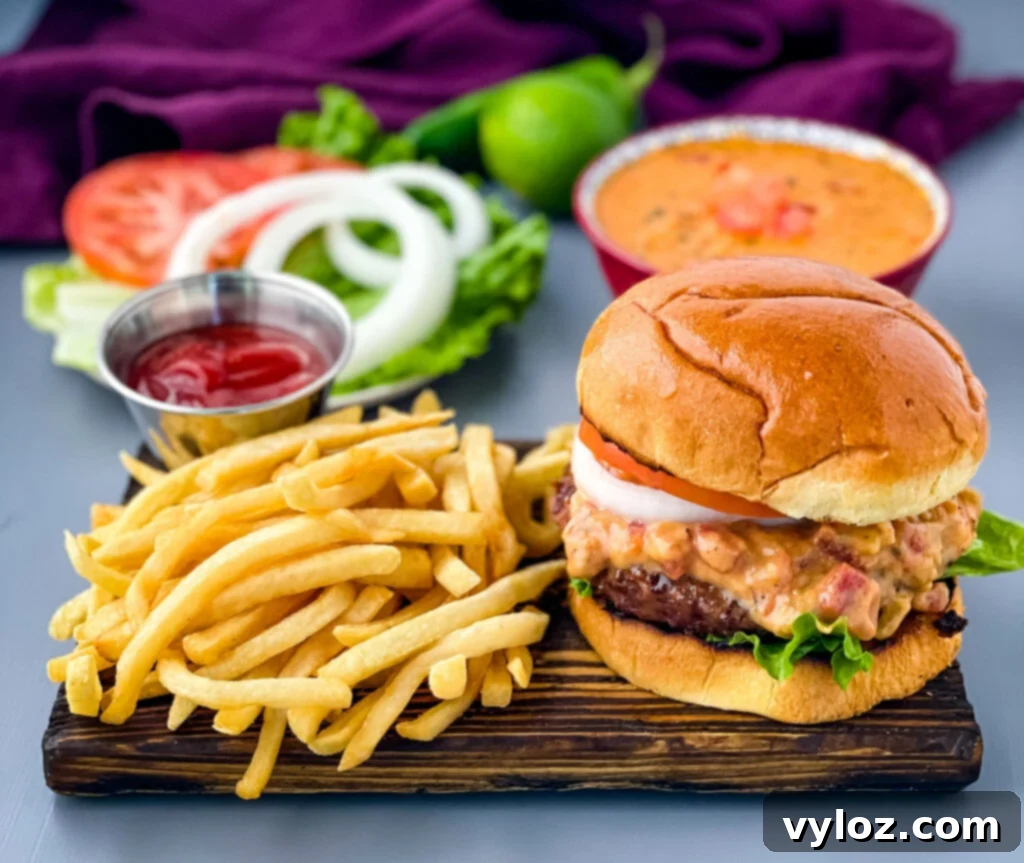 Gooey Queso Burgers 2 Delicious queso burgers served on a plate with crispy French fries, showcasing melted cheese