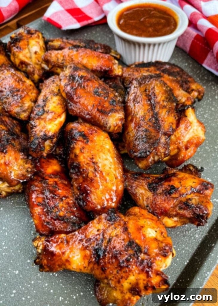 Perfect Grilled Chicken Wings 11 Plated grilled chicken wings with a side of BBQ sauce and a refreshing drink