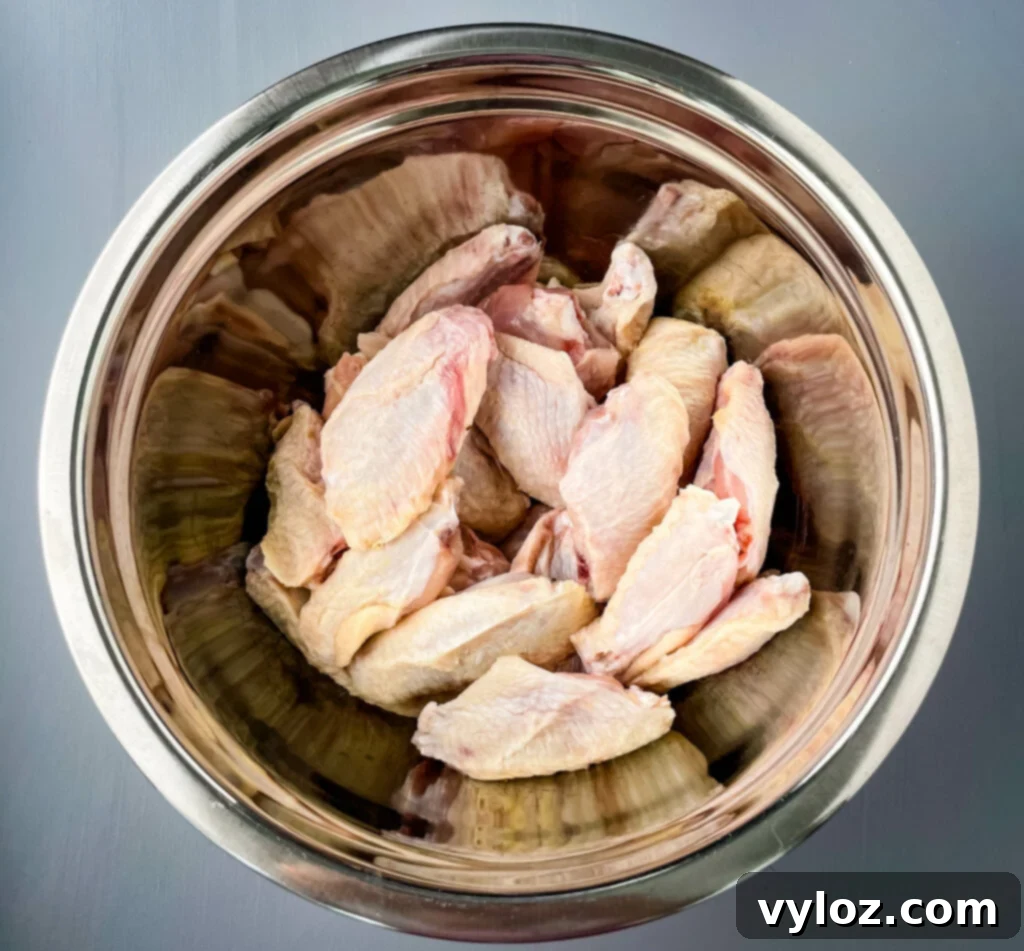 Perfect Grilled Chicken Wings 3 Raw chicken wings in a large bowl, ready for seasoning