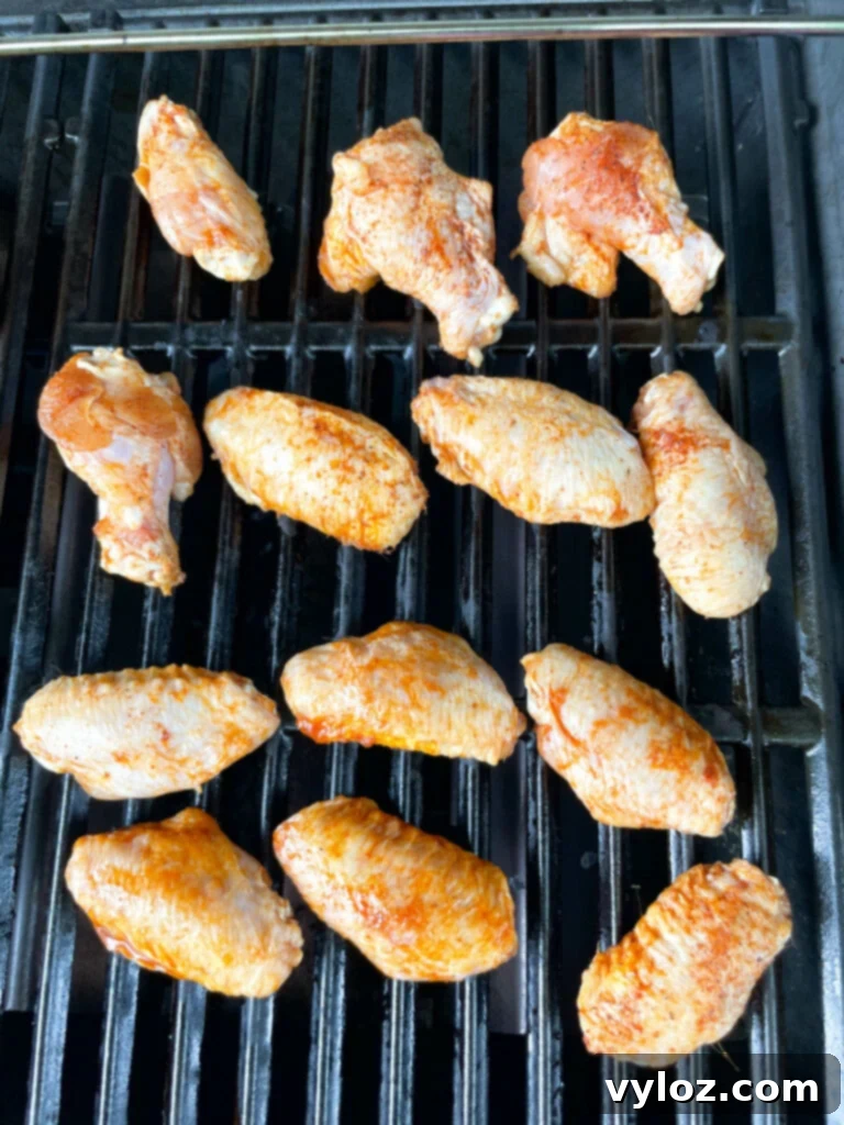 Perfect Grilled Chicken Wings 6 Raw chicken wings laid out on a hot grill, ready to cook