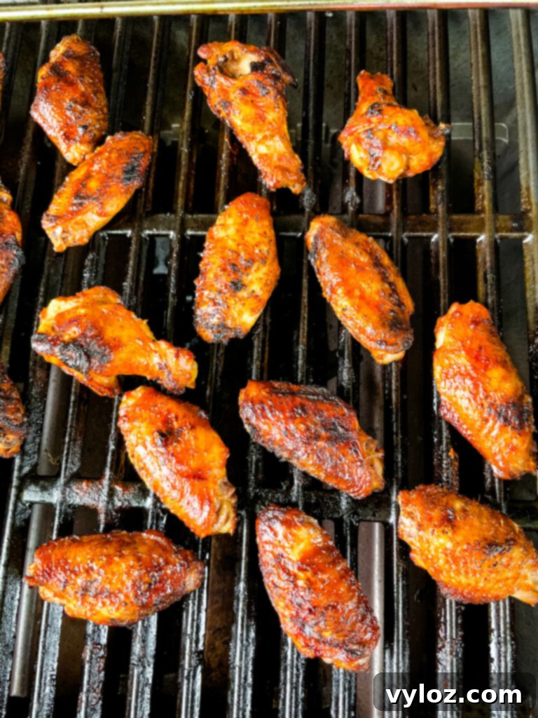 Perfect Grilled Chicken Wings 8 Grilled chicken wings sizzling on the barbecue grates, with a golden-brown finish