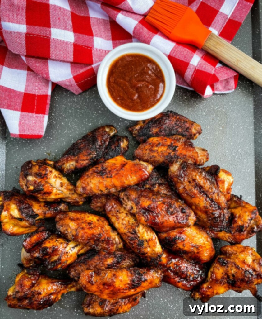 Perfect Grilled Chicken Wings 10 A plate of perfectly grilled chicken wings, some with BBQ sauce, ready to be enjoyed