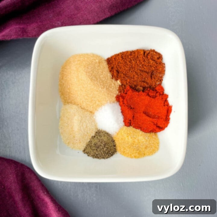 A glass container filled with Homemade BBQ Seasoning and Rub, ready to be applied to meats or vegetables.