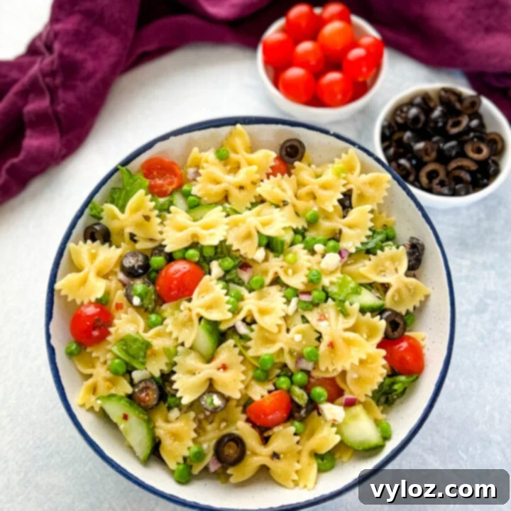 Colorful Bow Tie Pasta Salad with vibrant vegetables, feta cheese, olives, and a zesty Italian dressing.