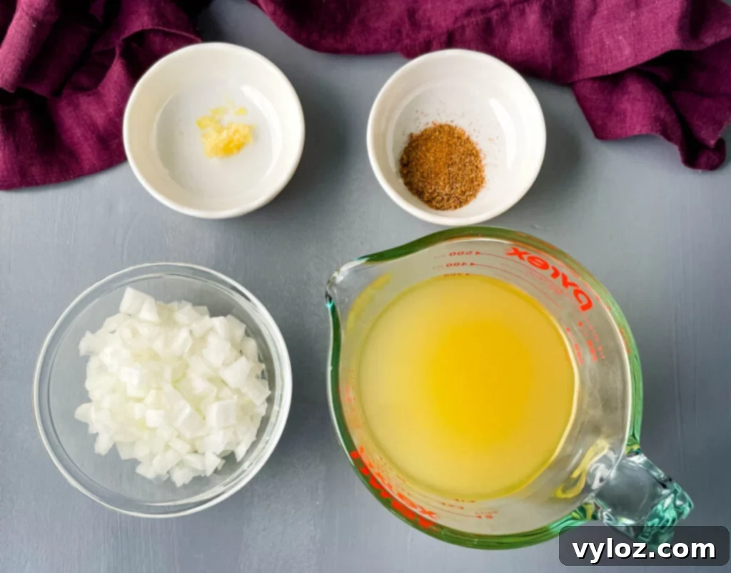 Bowls of garlic, Creole seasoning, chopped onions, and chicken broth, ingredients for collard greens.