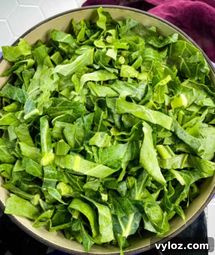 Shredded collard greens simmering in a pot, ready to be seasoned.