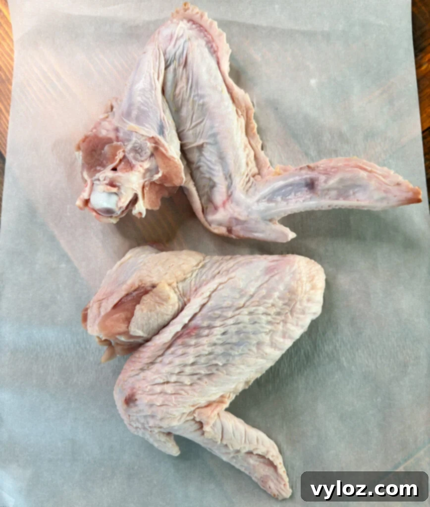 Succulent Roasted Turkey Wings 5 raw turkey wings on parchment paper