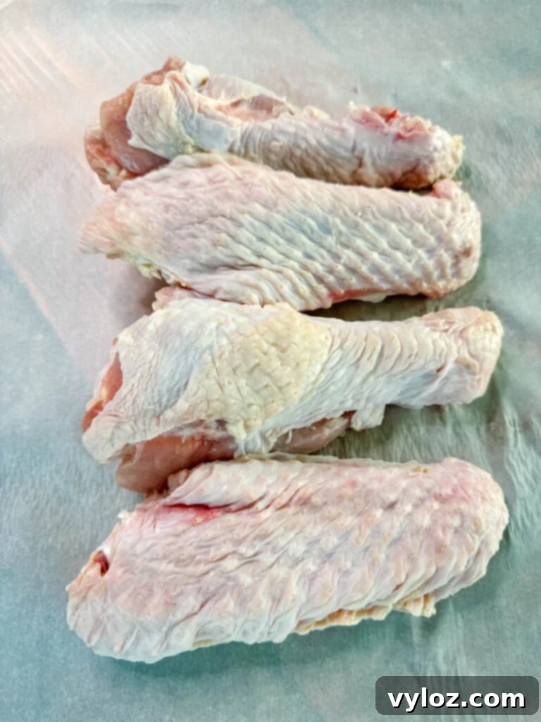 Succulent Roasted Turkey Wings 6 raw turkey wings on parchment paper