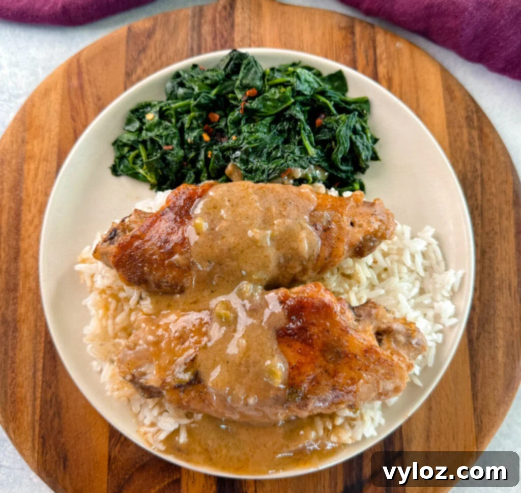 Smothered turkey wings and gravy on a plate with fresh spinach