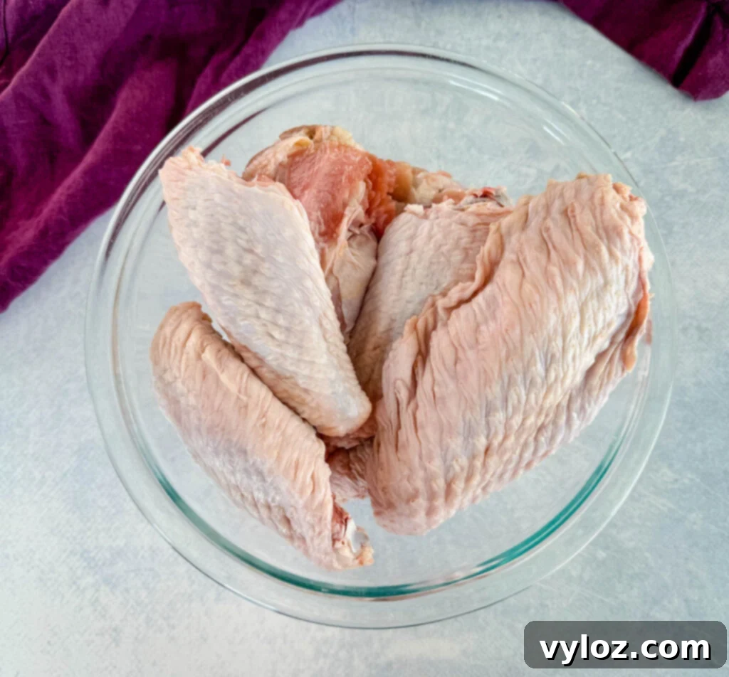 Raw turkey wings in a glass bowl, ready for seasoning