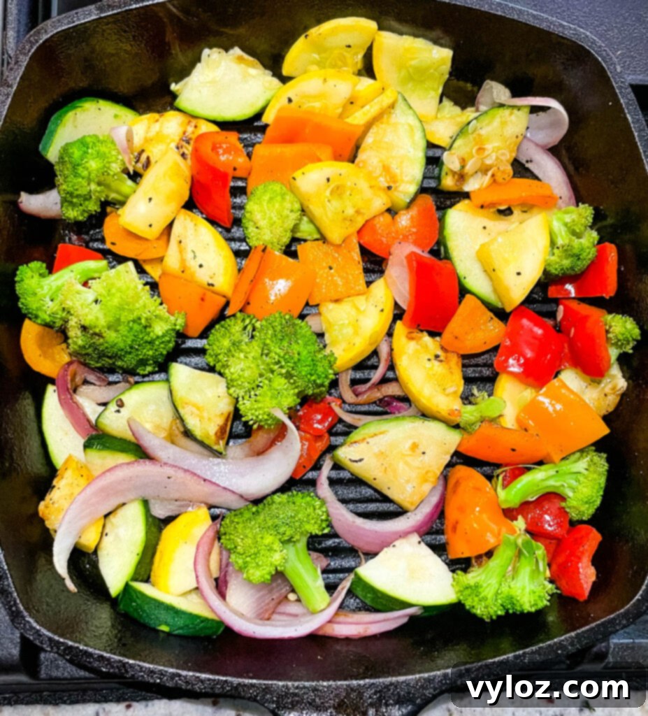 Close-up of colorful bell peppers and zucchini grilling on an outdoor grill