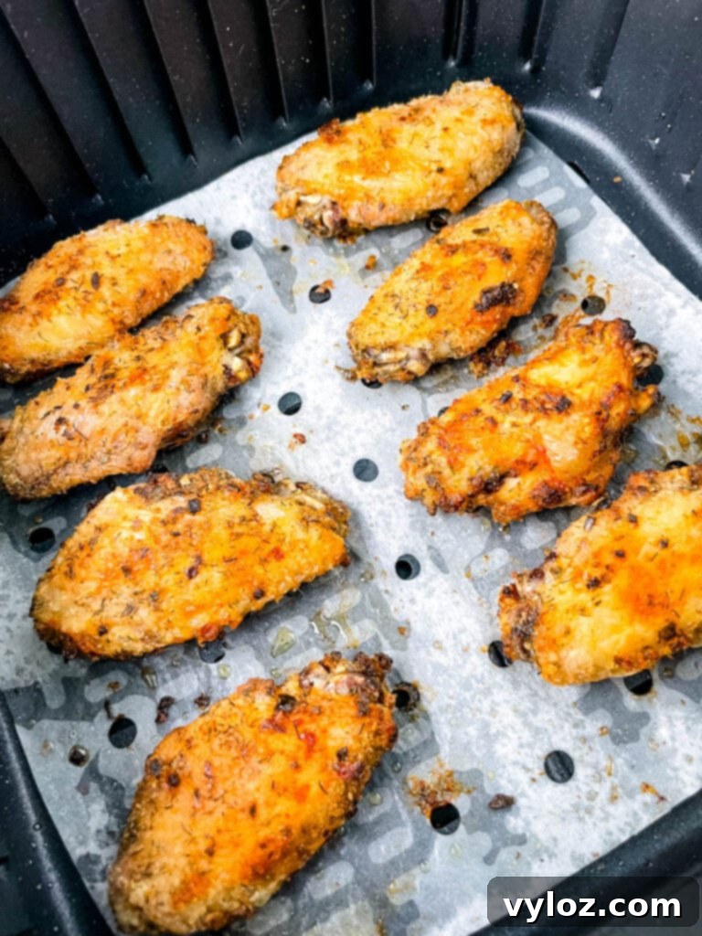 Close-up of crispy ranch chicken wings in an air fryer, showing their golden and textured surface.
