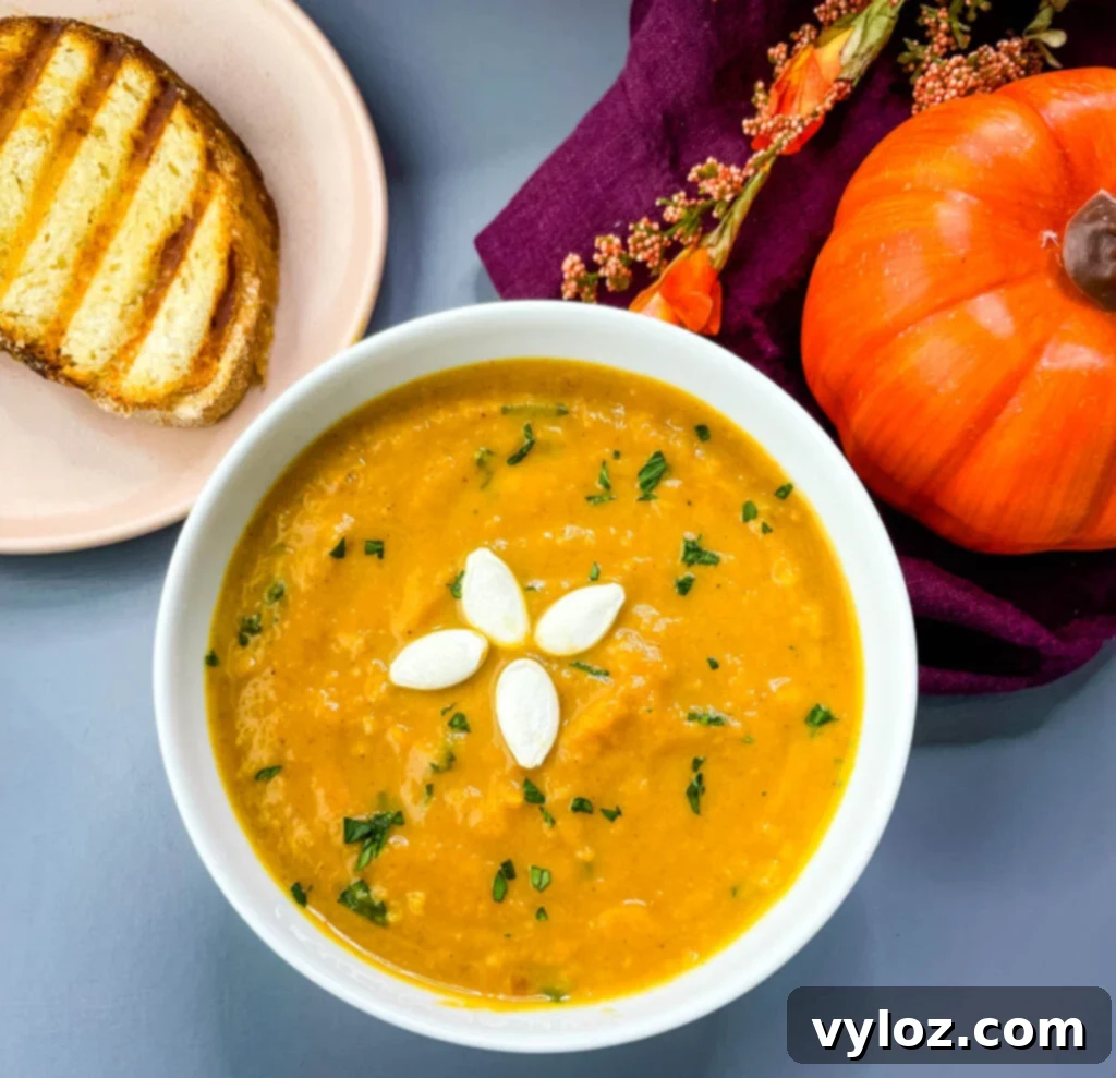 Quick Creamy Pumpkin Soup with Canned Pumpkin 5 creamy canned pumpkin soup in a white bowl with a slice of bread on the side