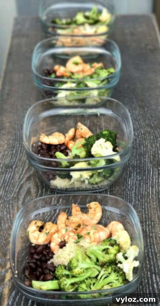 Individual meal prep containers with Cilantro Lime Shrimp Quinoa Bowl components